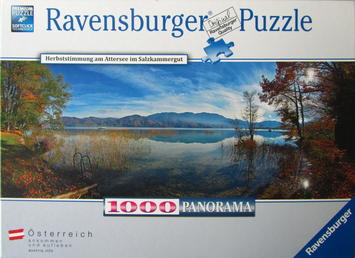 A panoramic landscape photograph of Attersee lake in Austria during the autumn season.