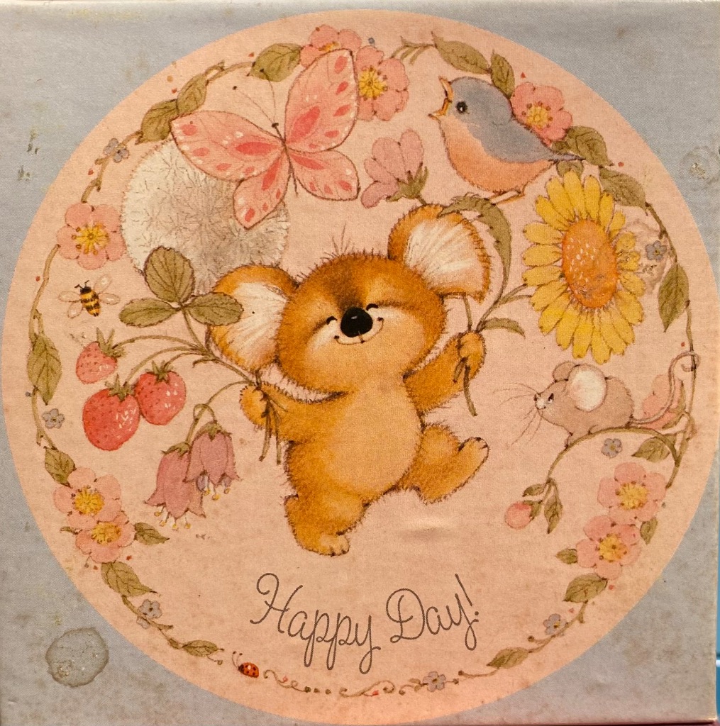 Illustration of a cute koala surrounded by flowers, a butterfly, and small animals in a circular frame.