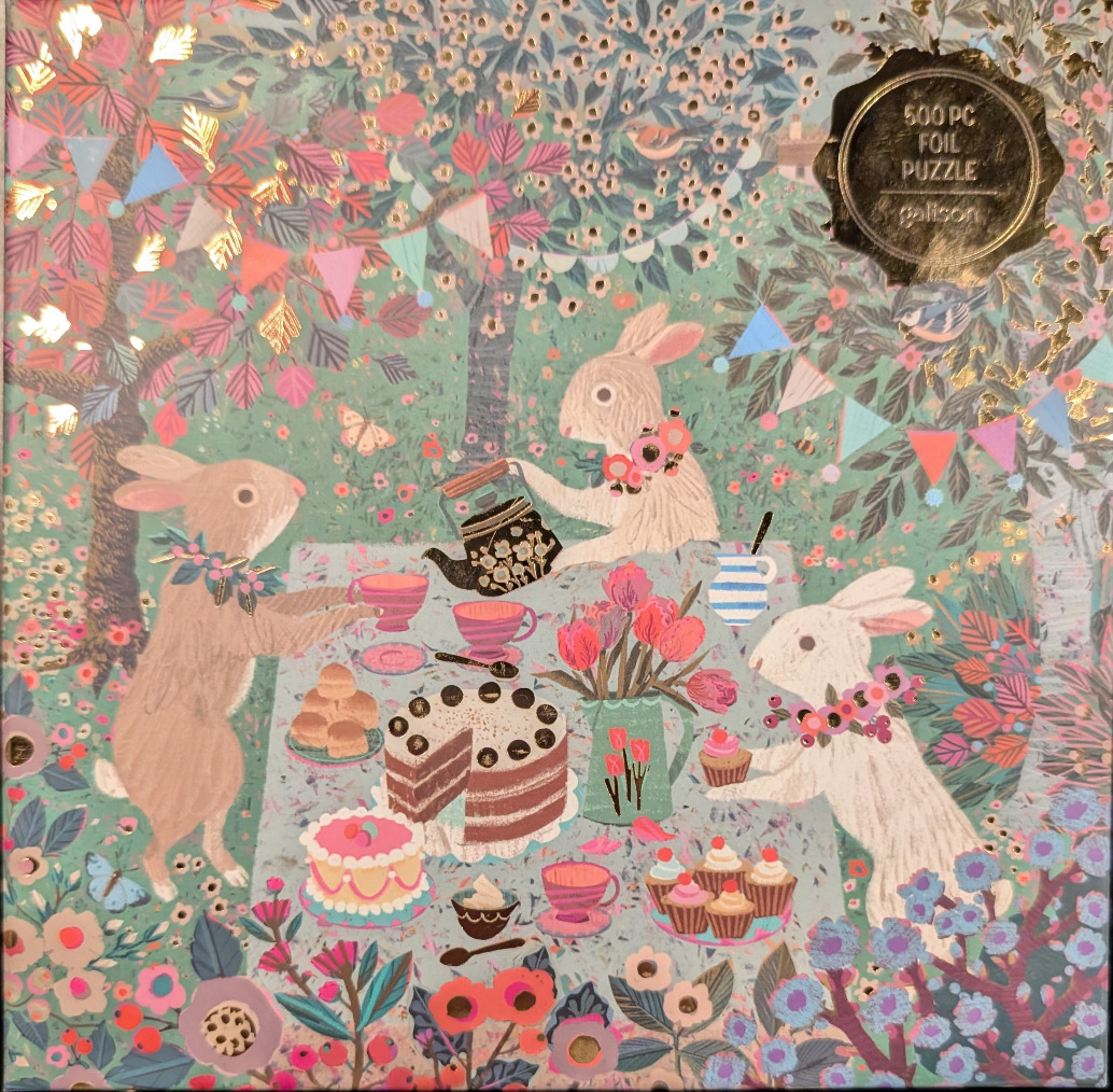 Illustration of three rabbits having an outdoor tea party in a whimsical garden setting with gold foil accents.