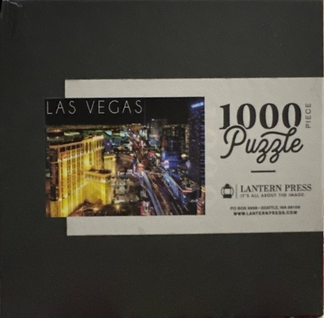 Aerial night view of the Las Vegas Strip with bright lights and high-rise hotels.