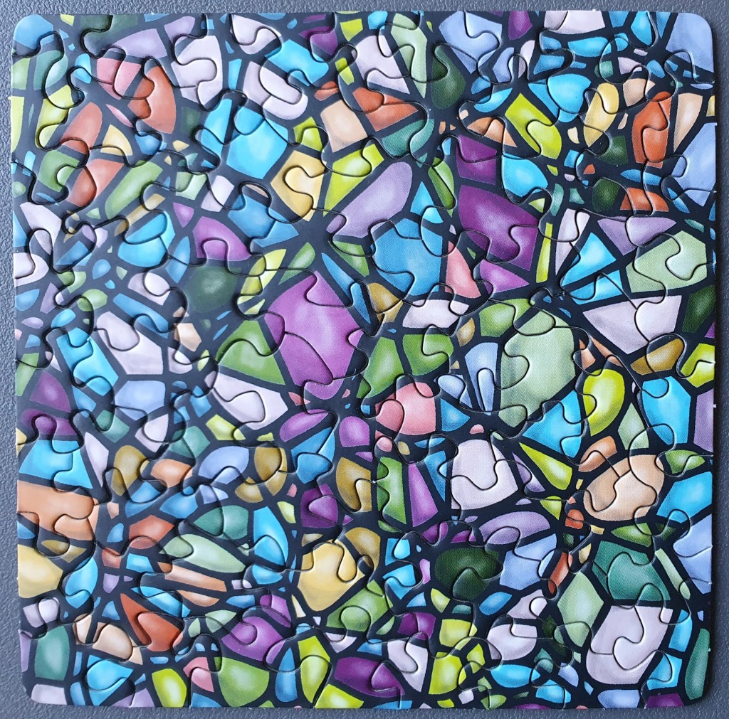 Abstract mosaic pattern of colorful geometric shapes framed by bold black lines resembling stained glass.
