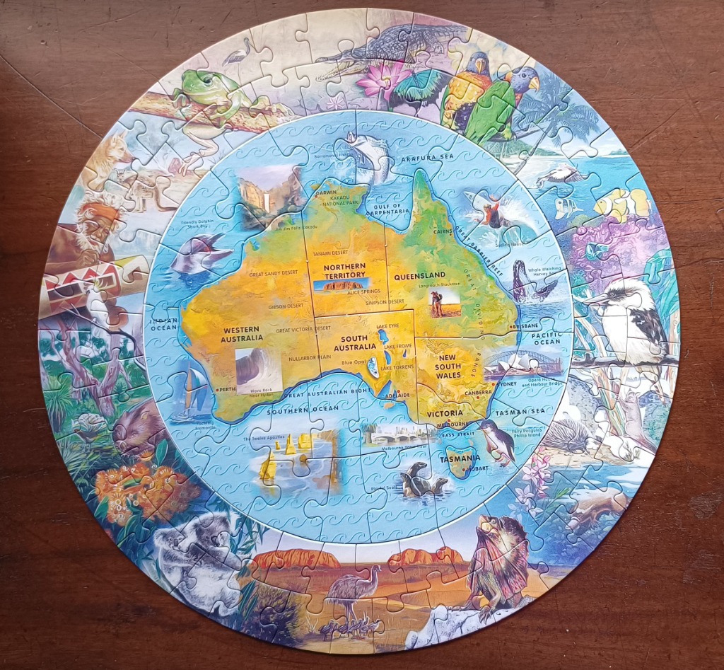 Circular illustration of a map of Australia surrounded by Australian flora and fauna.