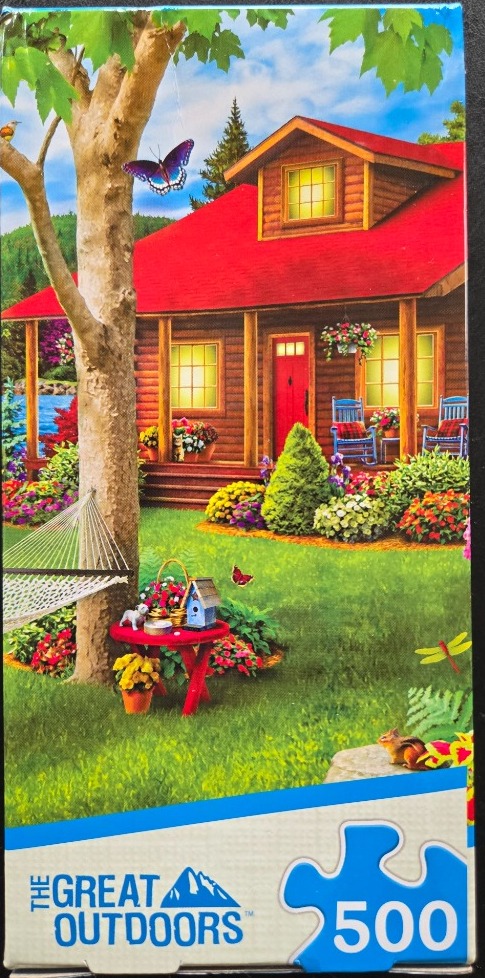 A cozy log cabin with a red roof sits in a lush garden with a hammock, a red table, and butterflies.
