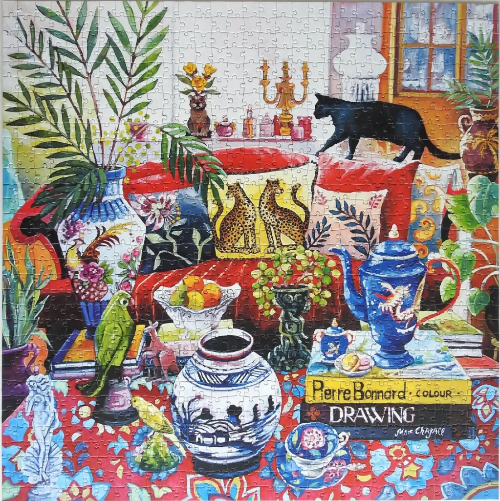 A vibrant, painterly interior scene featuring a cat, a parrot, decorative pottery, and art books on a patterned table.