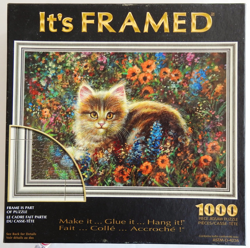 Painting of a fluffy kitten sitting in a vibrant garden of wildflowers framed by an ornate silver border.