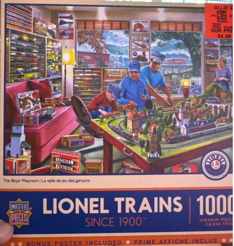 A father and two sons playing with an elaborate model train set in a cozy, train-themed playroom.