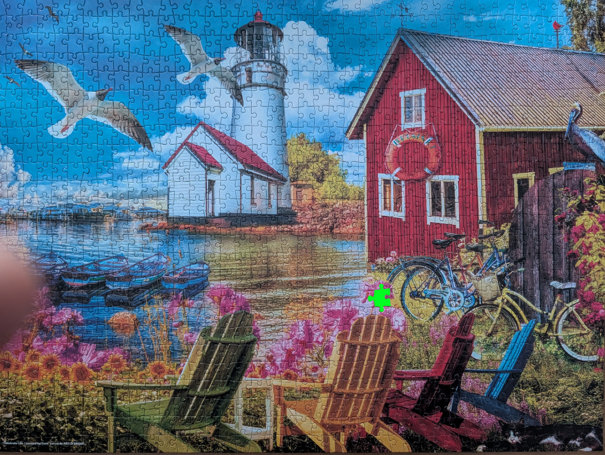 A seaside scene with a lighthouse, a red barn, and colorful Adirondack chairs overlooking a lake.