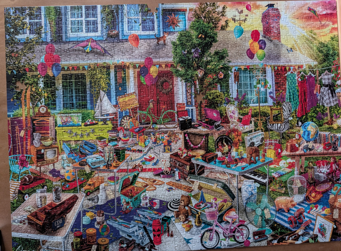 A bustling yard sale filled with vintage items, toys, and household goods in front of a suburban home.