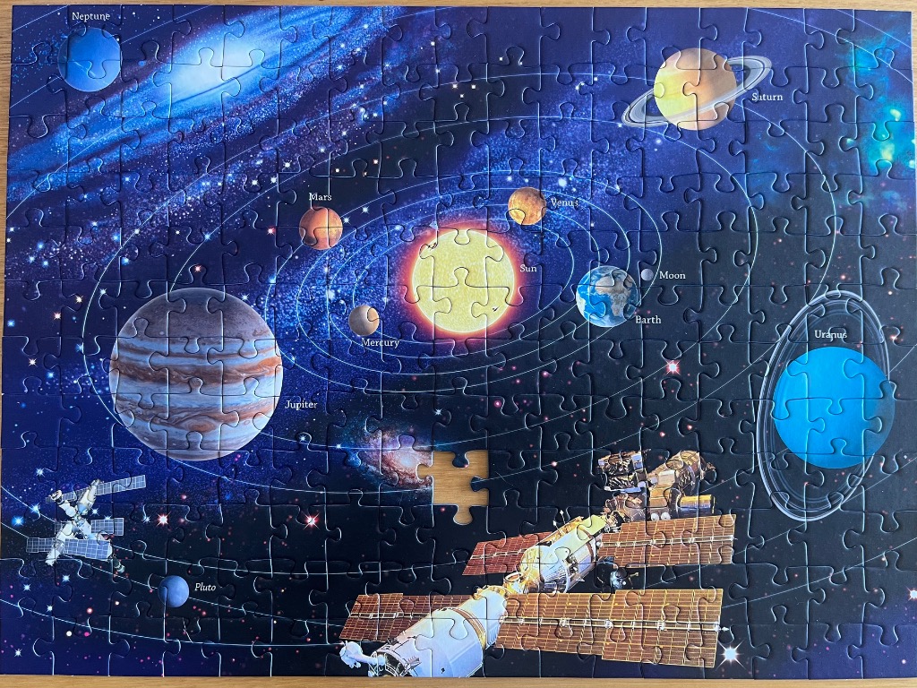 A detailed illustration of the solar system featuring the sun, all nine planets, and a space station.