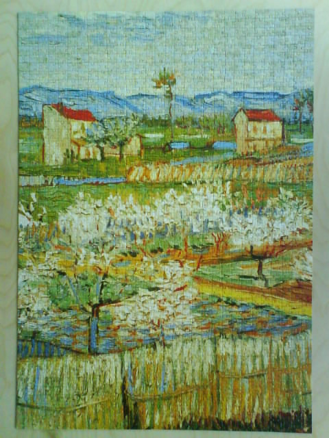 Post-impressionist painting of a blooming orchard with houses and mountains in the background.