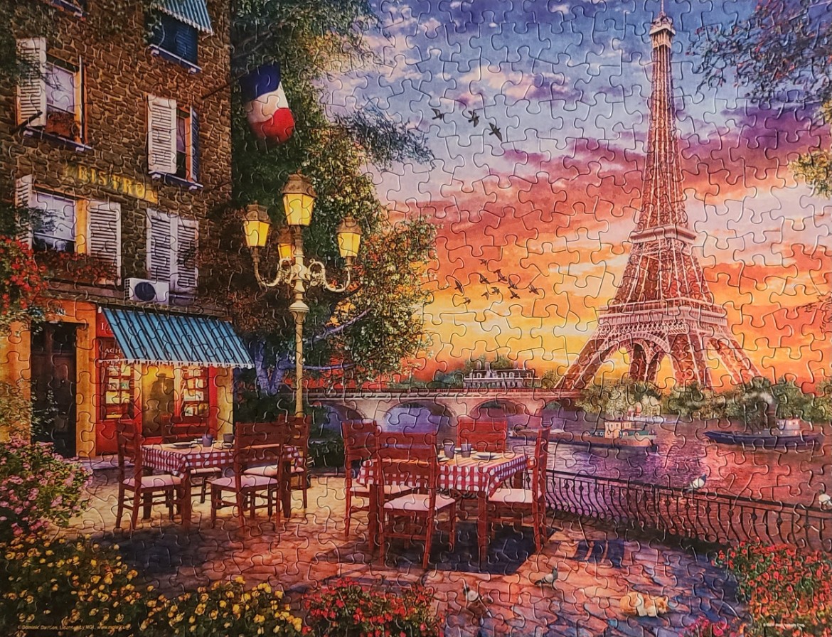 A romantic Paris bistro scene at sunset with the Eiffel Tower in the background.
