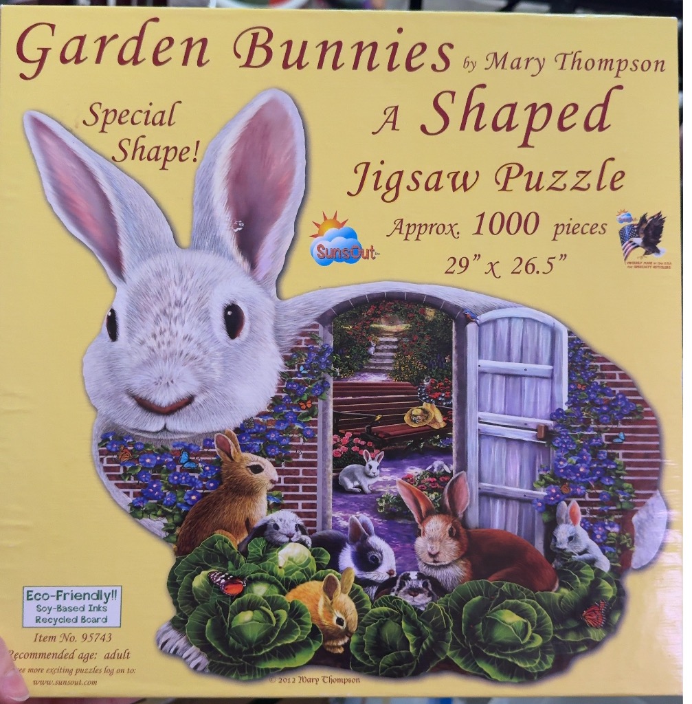 An illustration of several rabbits in a garden, with a large white rabbit head framing an arched garden entrance.