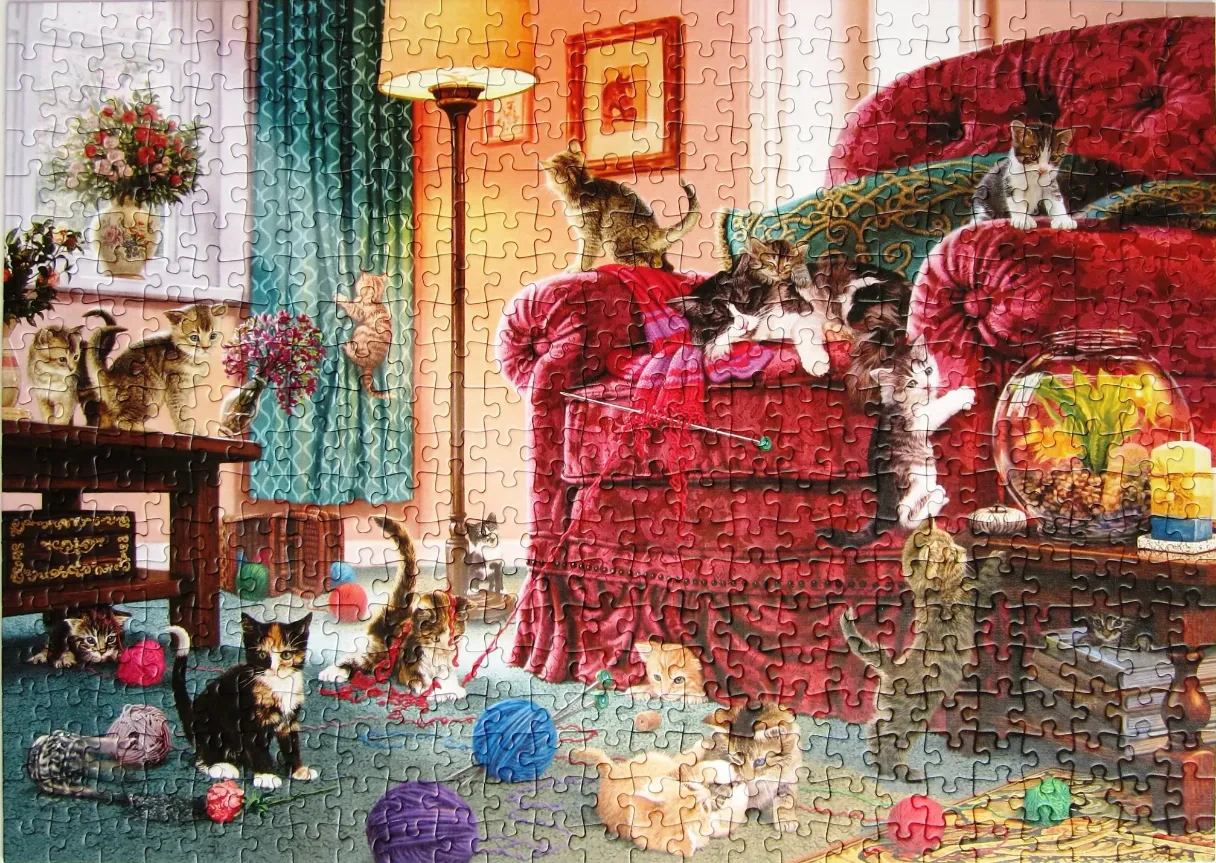 A cozy living room filled with many playful kittens, yarn balls, and a large velvet armchair.