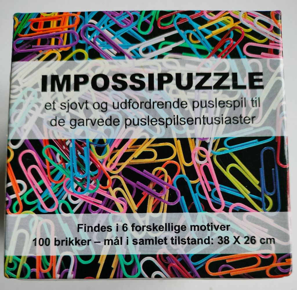 A chaotic, colorful pile of metal paperclips in blue, yellow, green, orange, purple, and pink on a black background.