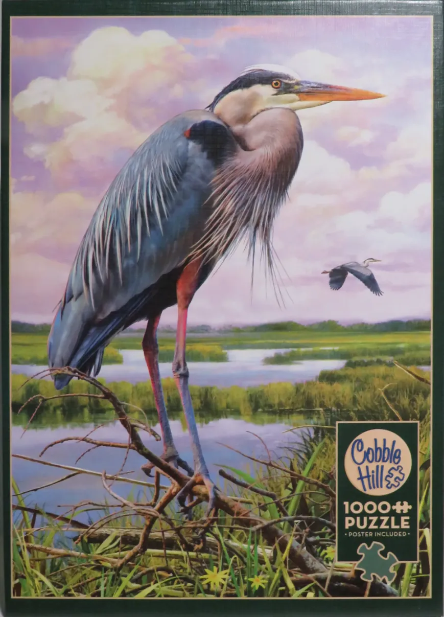 A Great Blue Heron perched on a branch overlooking a marsh at sunset.