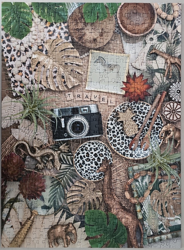 A flat lay composition of safari-themed travel items and tropical greenery on a woven background.