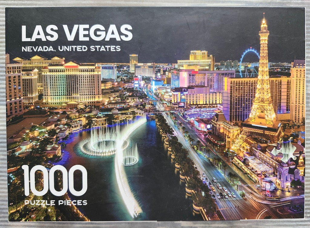 A nighttime aerial view of the Las Vegas Strip featuring the Bellagio fountains and a replica Eiffel Tower.
