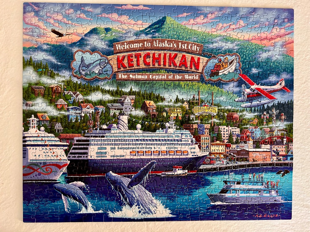 Illustration of Ketchikan, Alaska, featuring cruise ships, mountains, whales, and a red seaplane.