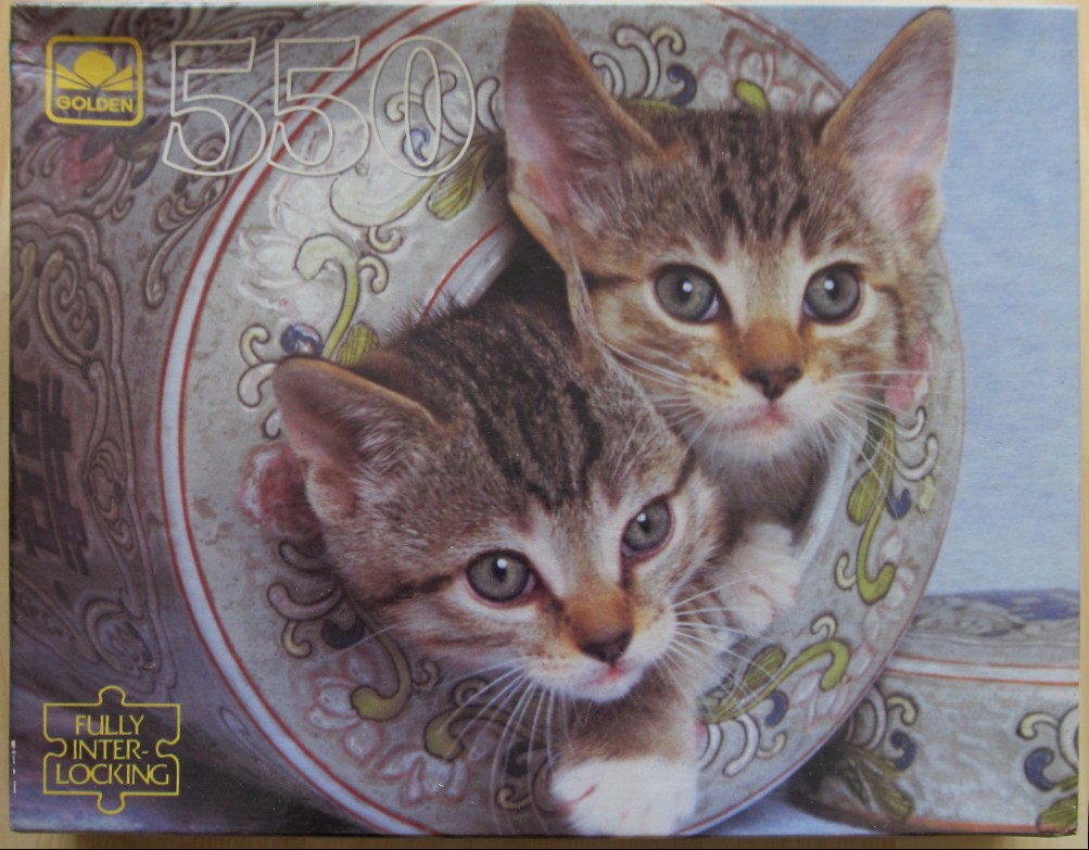 Two tabby kittens peeking out of a decorative porcelain jar.