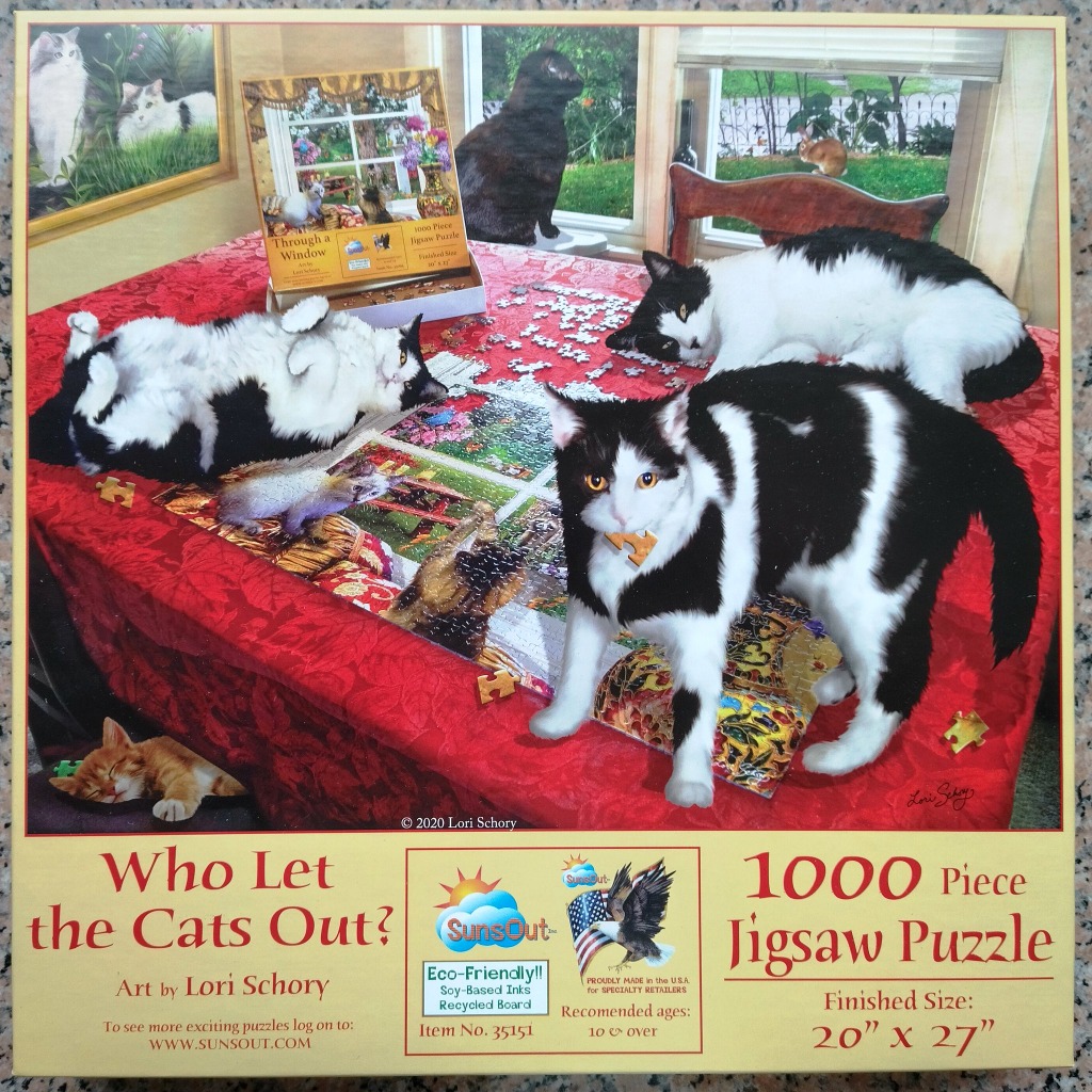 A collection of black and white cats playing on a table covered by a red cloth with an unfinished jigsaw puzzle.