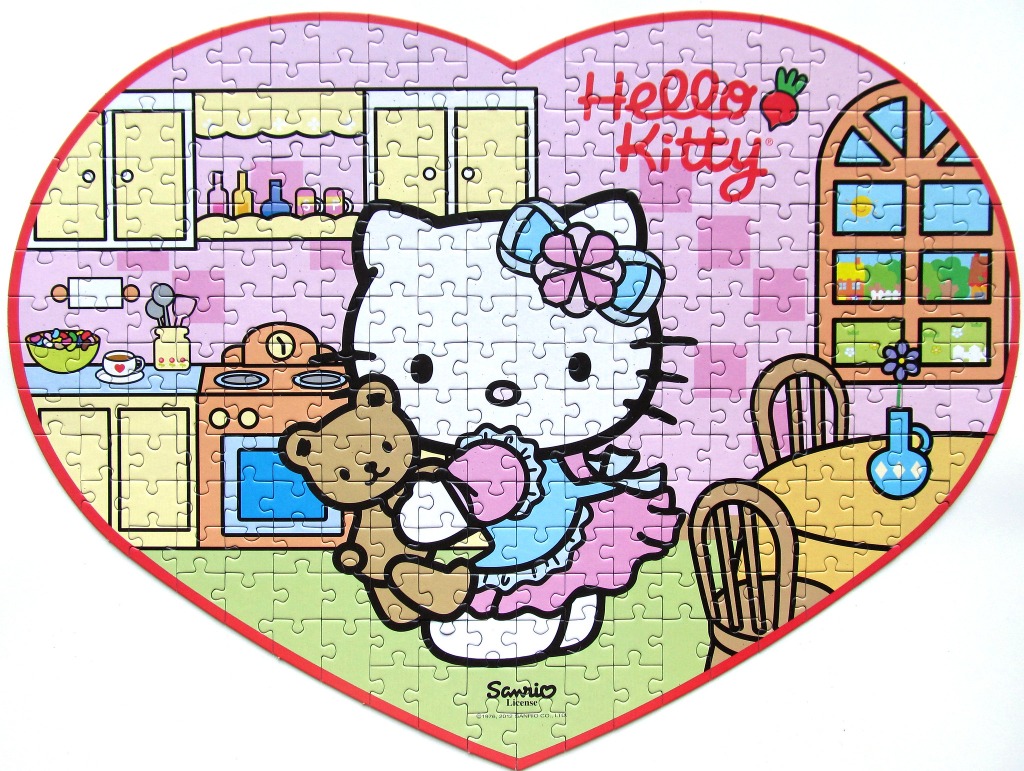 Heart-shaped illustration of Hello Kitty holding a teddy bear in a kitchen scene.