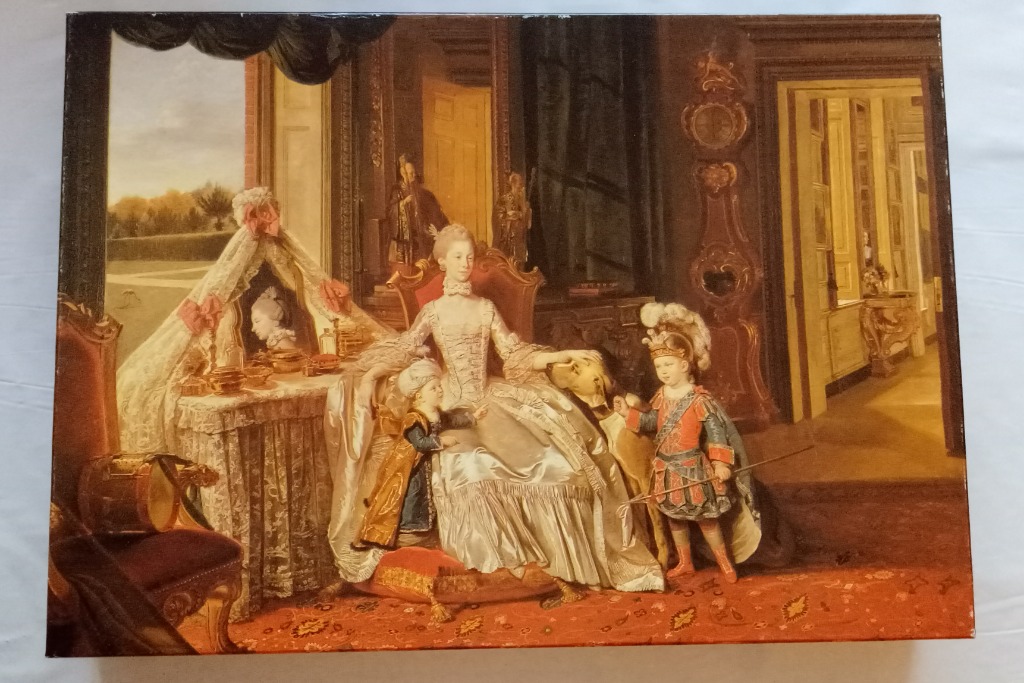 An 18th-century style oil painting of a woman seated in a room with two young boys dressed in ornate historical costumes.
