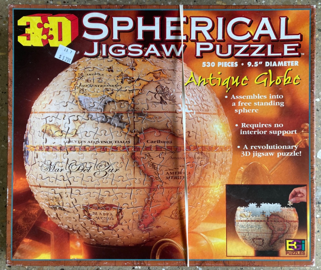 An antique-style globe map printed on a spherical puzzle surface.