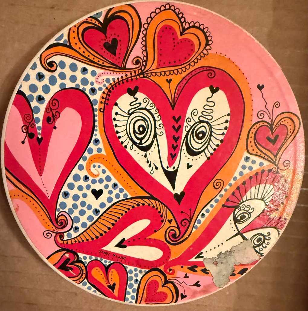 Circular illustration featuring stylized hearts in vibrant shades of pink, orange, and blue on a polka-dot background.