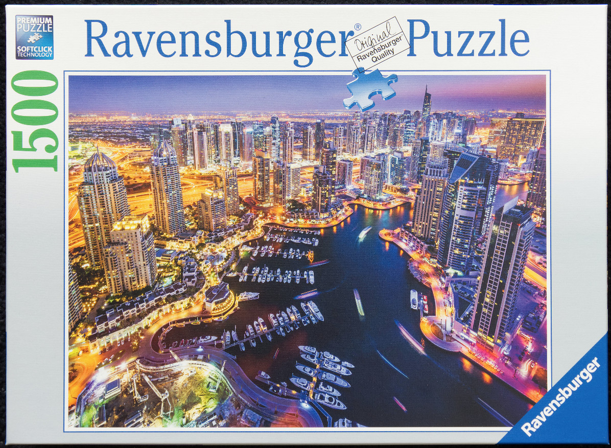 Aerial night view of the Dubai Marina skyline and yachts at sunset.