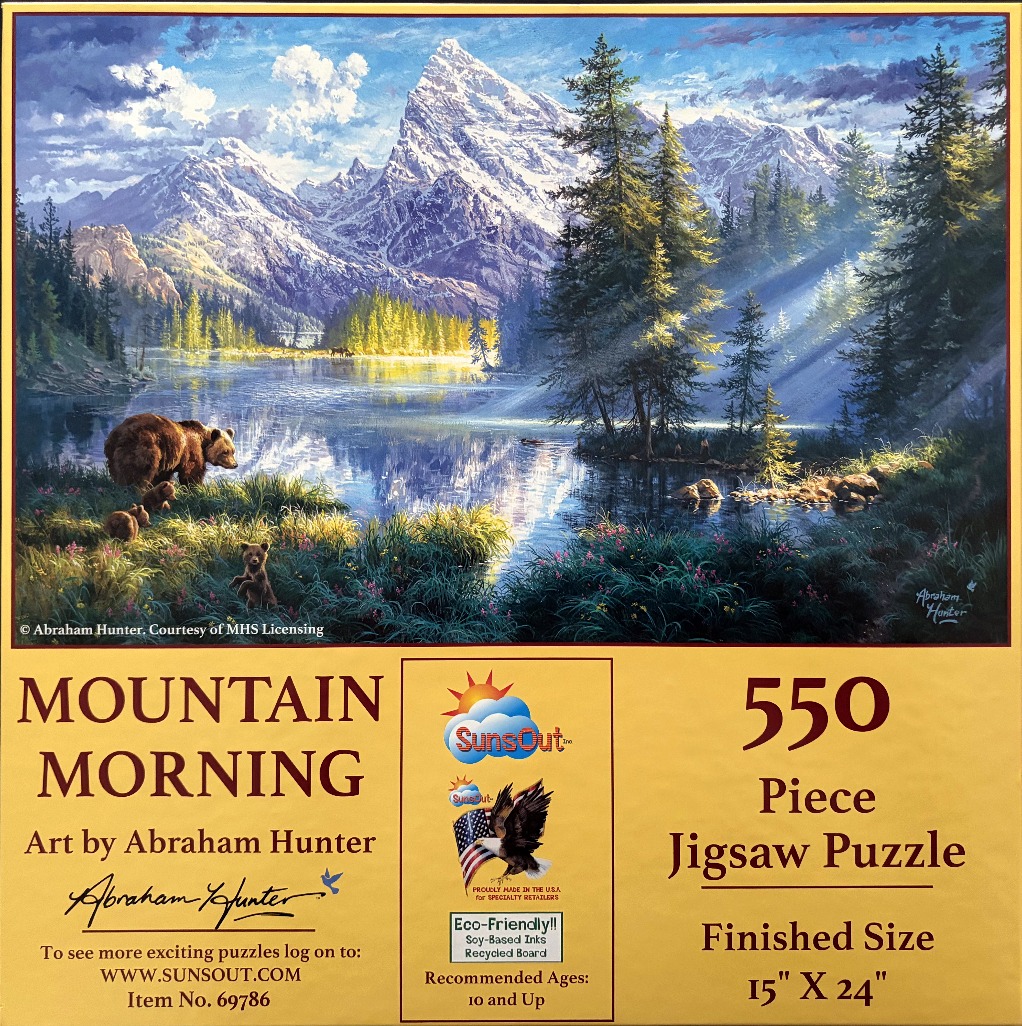A mother bear and two cubs stand by a serene mountain lake beneath snow-capped peaks in the morning light.