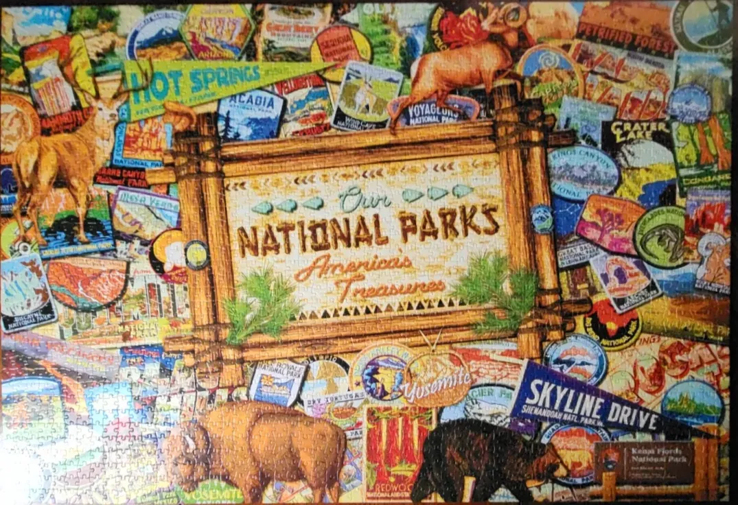 Collage of vintage National Park travel posters, pennants, and wildlife illustrations centered on a wooden park sign.
