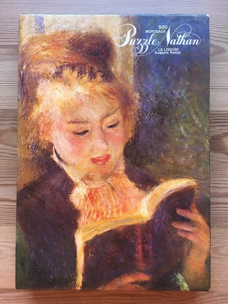 Impressionist oil painting of a woman reading a book by Auguste Renoir.