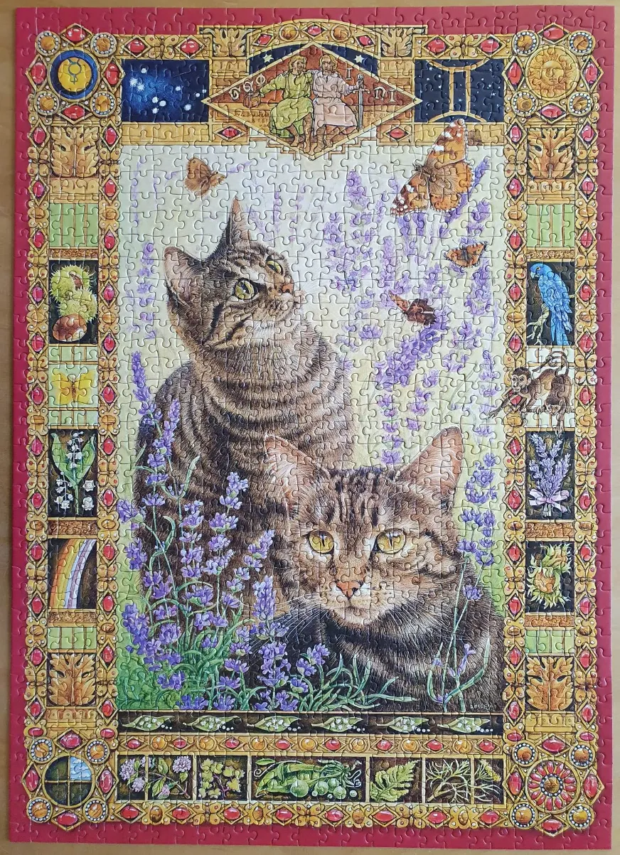 Two tabby cats surrounded by lavender and a decorative astrological border representing Gemini.