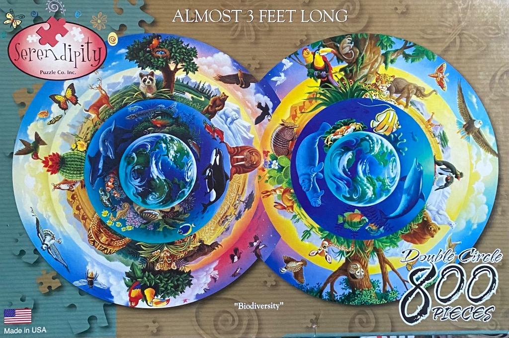 Circular biodiversity illustration featuring dual Earths surrounded by rings of various global animal species.
