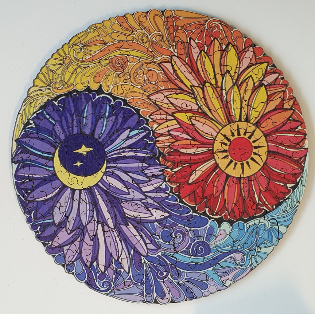 Circular illustration of a sun and moon yin-yang design made of stylized flowers.