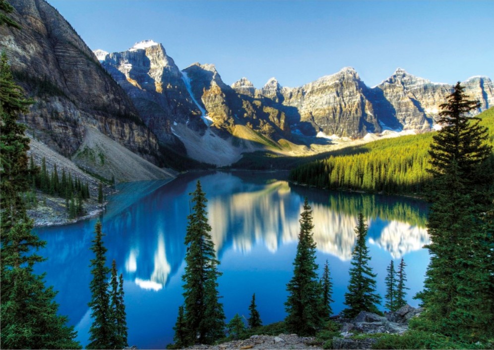 A stunning landscape view of a bright blue glacial lake surrounded by the jagged, snow-dusted peaks of the Valley of the Ten 
