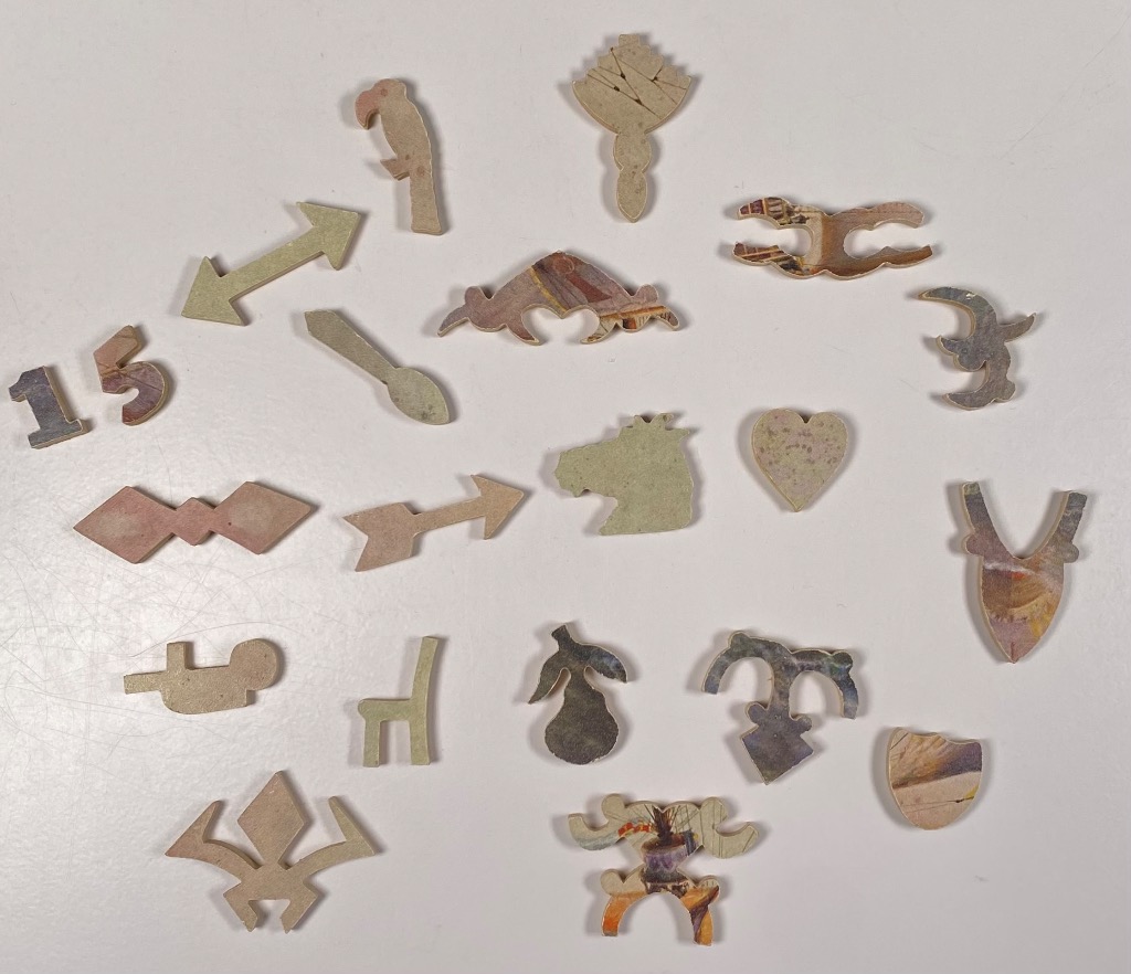 A collection of whimsically shaped cardboard objects in the silhouettes of animals, symbols, and geometric forms.