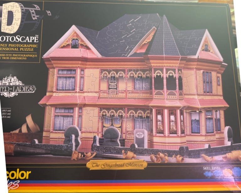 A detailed Victorian-style house known as The Gingerbread Mansion, featuring pale yellow siding and pink trim.