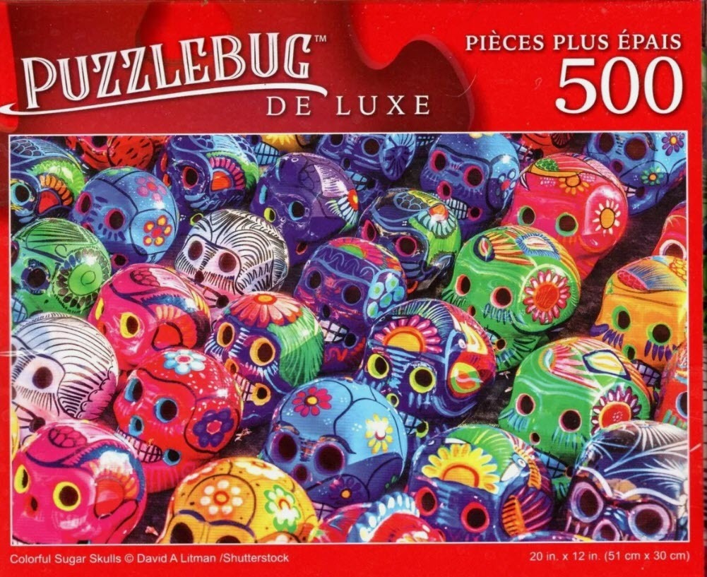 A close-up of many colorful, decorated sugar skulls arranged in a dense, overlapping pattern.