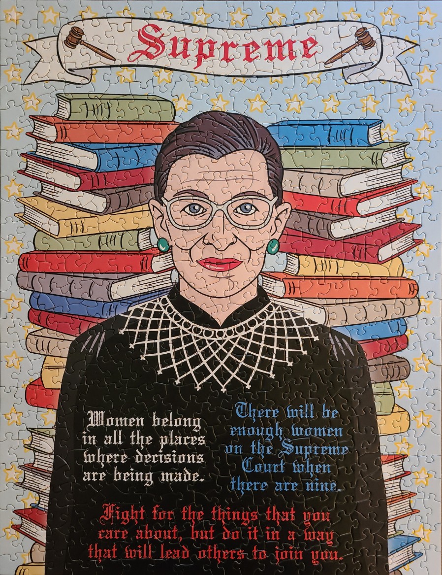 Illustration of Ruth Bader Ginsburg in front of stacks of books with inspirational quotes and a banner reading Supreme.