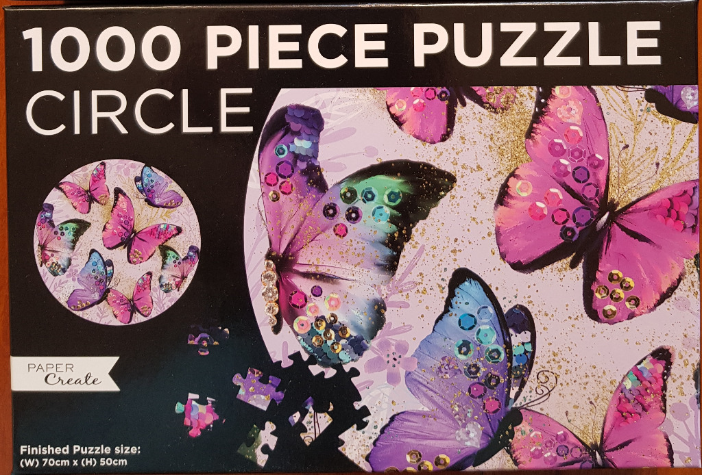 Close-up artwork of decorative purple and blue butterflies adorned with sequins against a light speckled background.