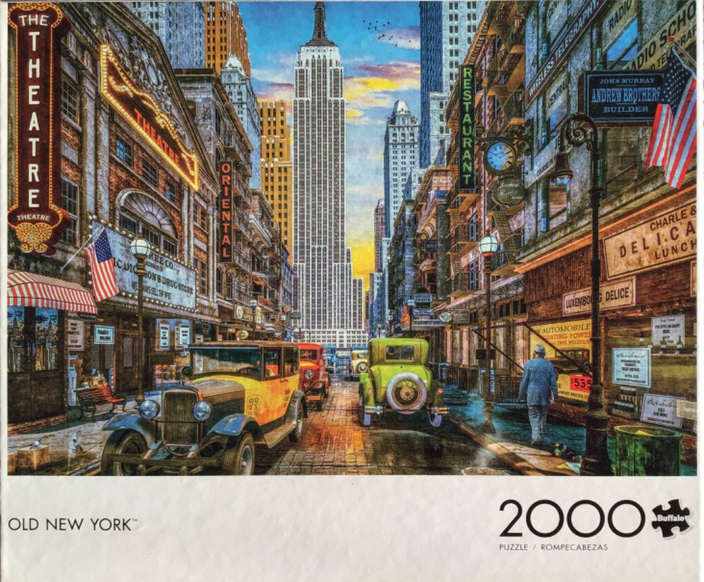 Vintage New York City street scene with the Empire State Building in the background and 1920s-era automobiles.