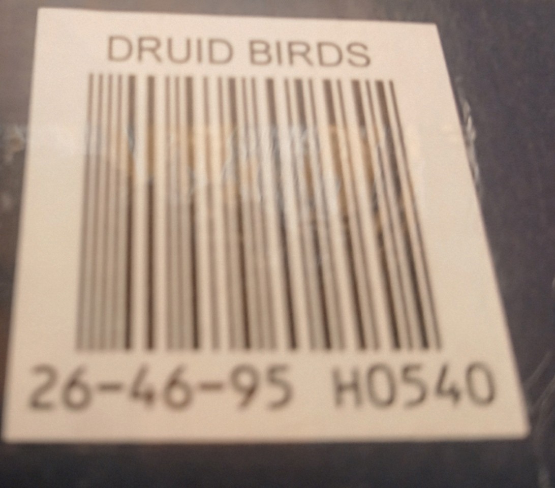 A close-up view of a product barcode sticker with the text DRUID BIRDS above and numeric codes below.