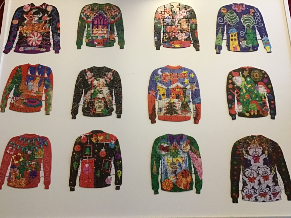A collection of twelve festive Christmas sweaters arranged in a grid on a white background.