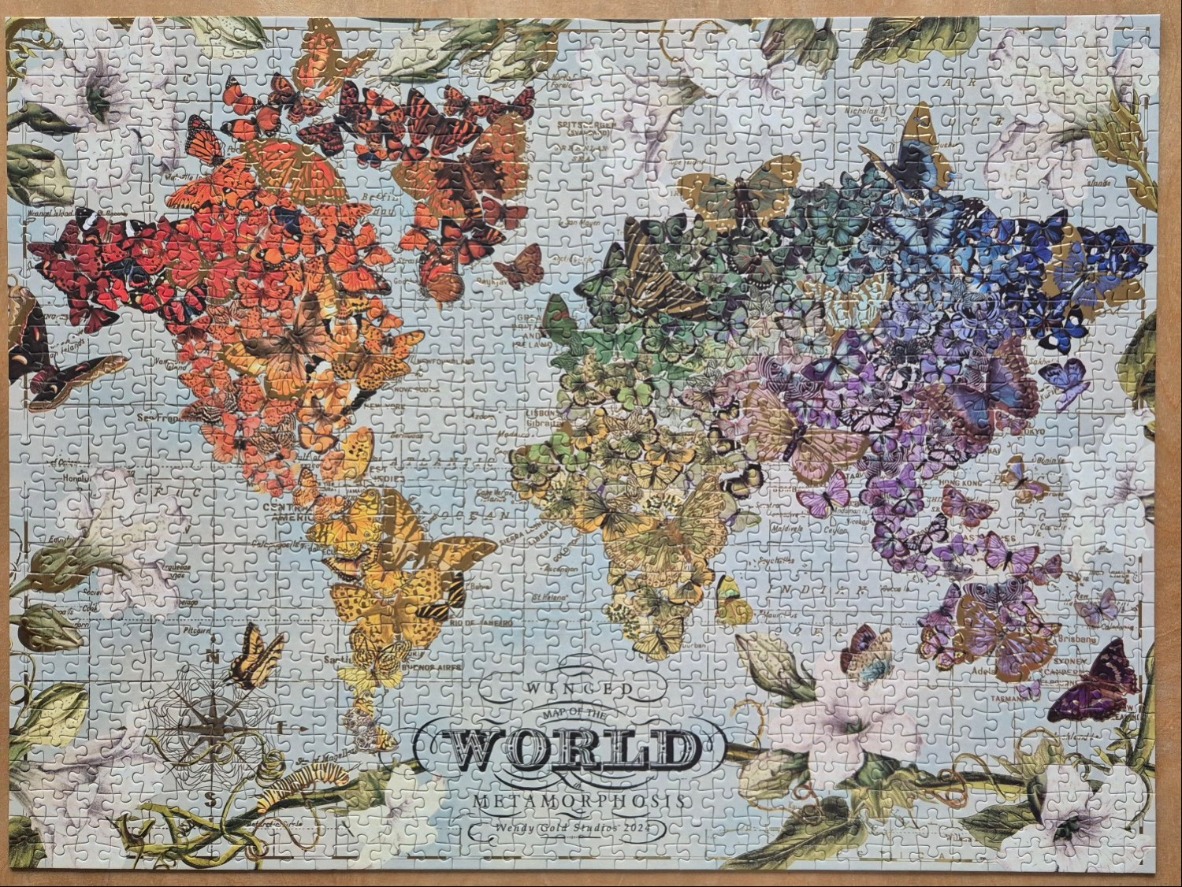 A world map illustration composed of colorful butterflies against a vintage background.