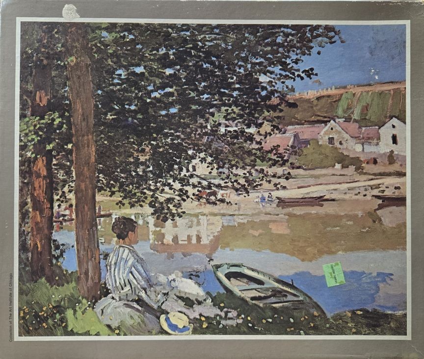 Impressionist painting of a woman sitting by a riverbank with boats and village houses in the background.