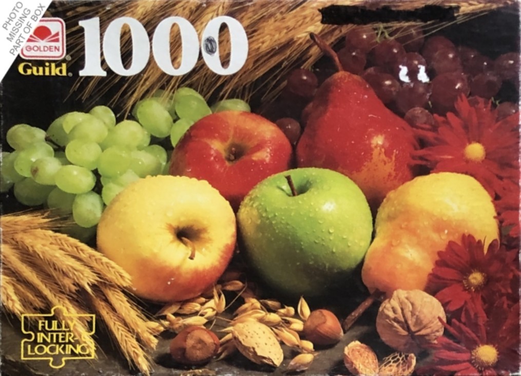 A still life arrangement of fresh fruits, nuts, and wheat stalks on a dark surface.