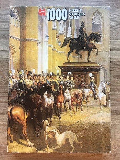 A group of 19th-century military officers on horseback in front of a large stone building with a statue.