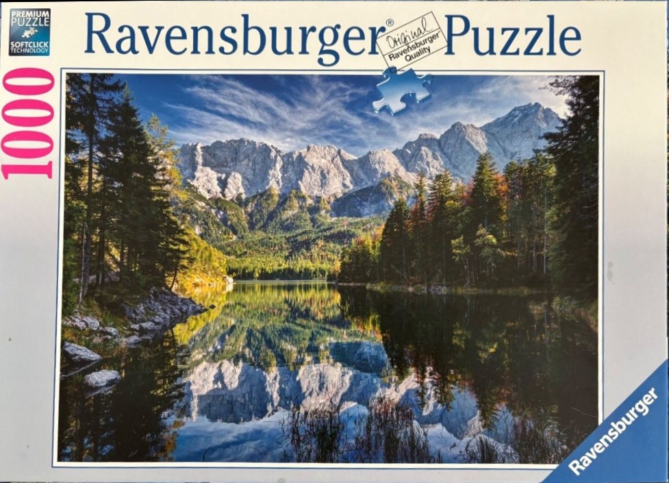 A photograph of Eibsee lake with reflections of the Zugspitze mountain range in the Bavarian Alps.