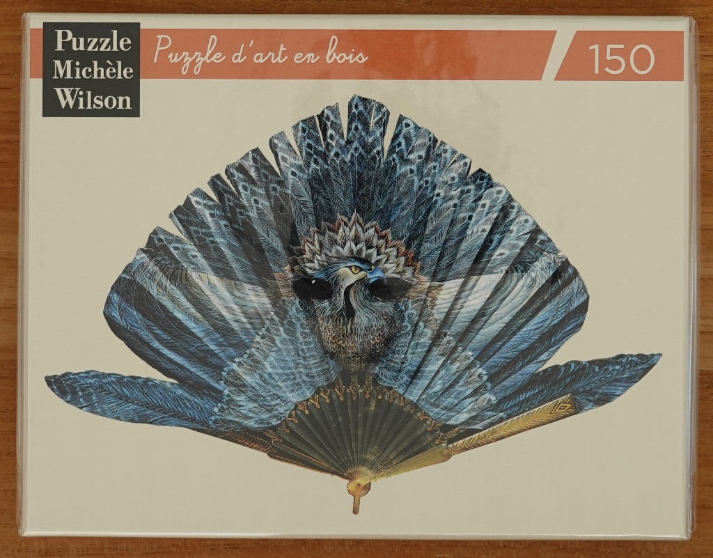 A decorative folding fan illustrated with the image of a blue bird of prey with expansive wings against a cream background.